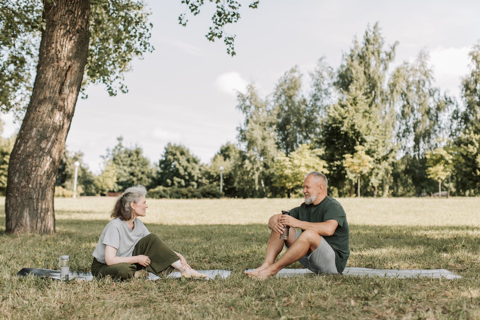 A Man and Woman Talking Together While Sitting on the Grass